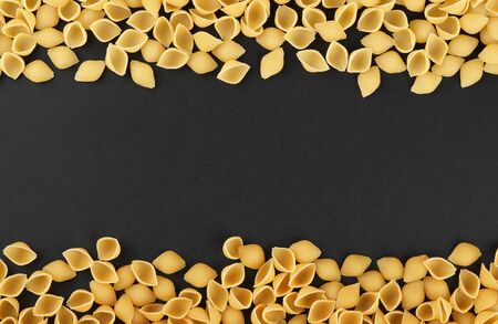 conchiglio pasta on black background top view