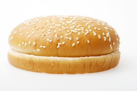 A hamburger bun on a light grey surface.の写真素材