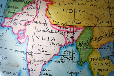 India on a worn, old and dirty metallic toy globeの写真素材