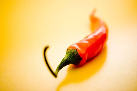 Red Chili Pepper on a yellow surfaceの写真素材