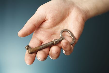 A Hand holding an old key.の写真素材