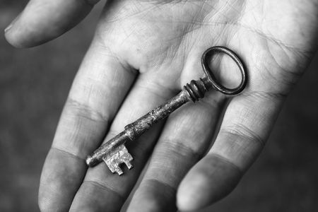 Black and white photo of an old key on a handの写真素材