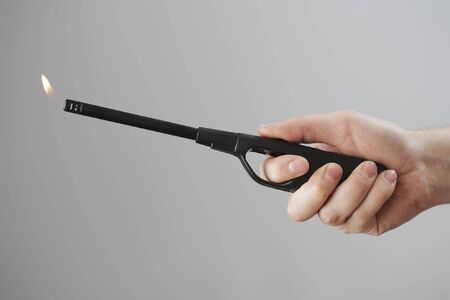 A hand using a fireplace lighter
