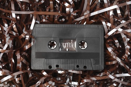 Old black audio C-cassette and tangled tapeの写真素材