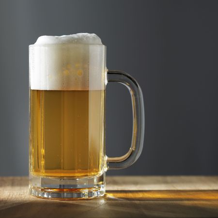 A glass of lager beer on wooden tableの写真素材