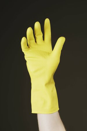 Hand with yellow protective rubber gloveの写真素材