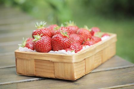 Fresh strawberries in a small wooden basketの写真素材