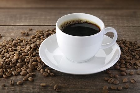 A Cup of coffee with some coffee beansの写真素材