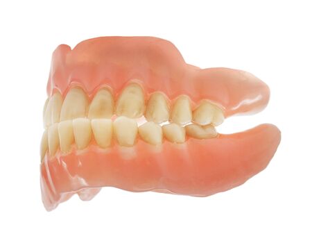 Old worn and dirty dentures isolated on whiteの写真素材