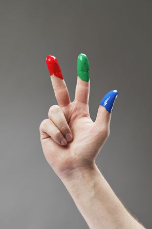 Fingers with fingerpaints in three primary colors, Red, green and blue.の写真素材