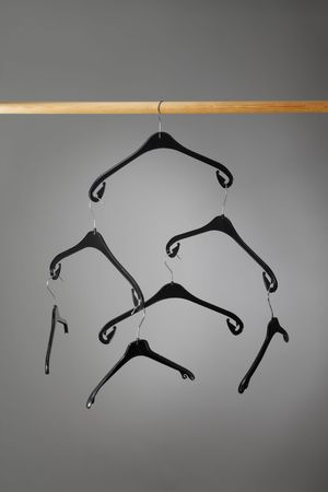 Empty black plastic clothes hangers hangingの写真素材