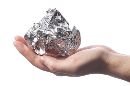 Hand holding a crumpled aluminum foil wrapの写真素材