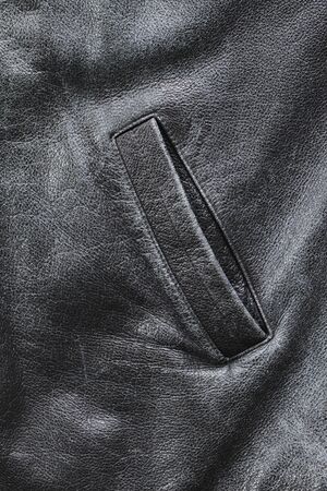 Pocket of an old worn black weather jacketの写真素材