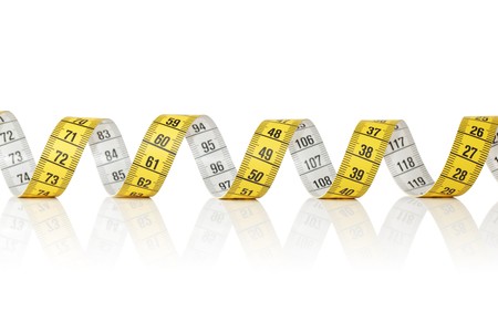Yellow and white metric tape measure on white reflecting backgroundの写真素材