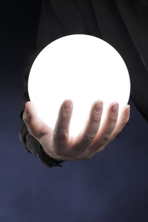 Man holding a glowing white sphere in his hand.の写真素材