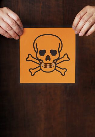 Man holding the symbol for poison in his hands.の写真素材