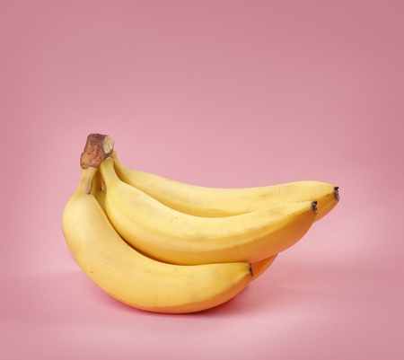 A Bunch of yellow bananas on pink backgroundの写真素材