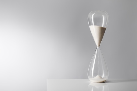 Studio photo of a hourglass on reflective table.の写真素材