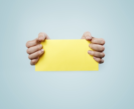 Hands holding a yellow card.の写真素材