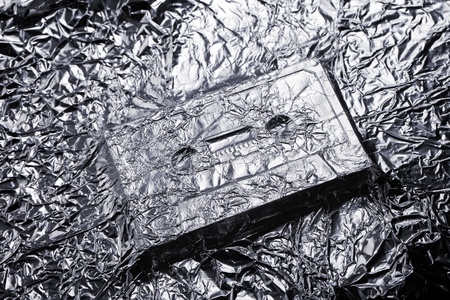 Audio compact cassette covered with aluminium foil.