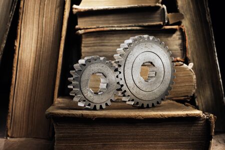 Still life with old metallic cog gears and antique books. Short depth of field.の写真素材