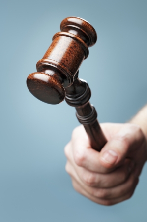 Man holding a wooden mahogany gavel in his hand. Short depth-of-field.の写真素材