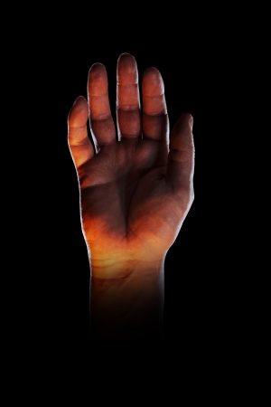 Bizarre image of a hand, lit with orange light from below.の写真素材