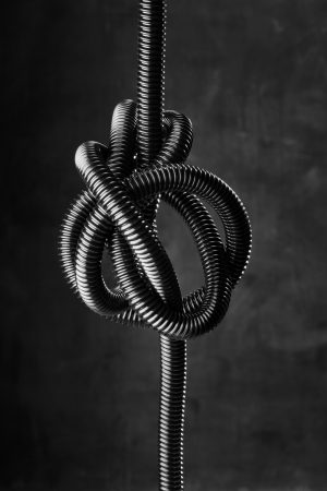 Black and white image of a black tangled flexible hose.の写真素材