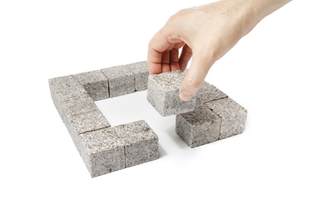 Man finishing a square made of small blocks of granite rock.の写真素材