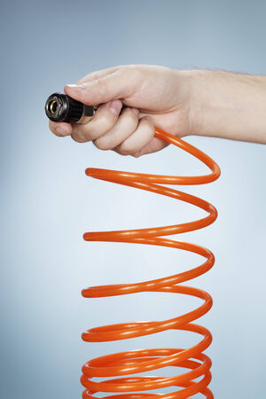 Man holding a pneumatic air hose connector in his hand.の写真素材
