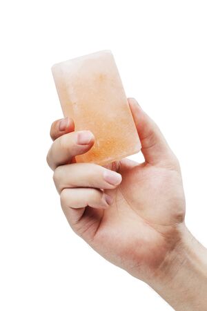 Man holding a himalayan salt soap bar, used for cleansing the skin or as a deodorant.の写真素材