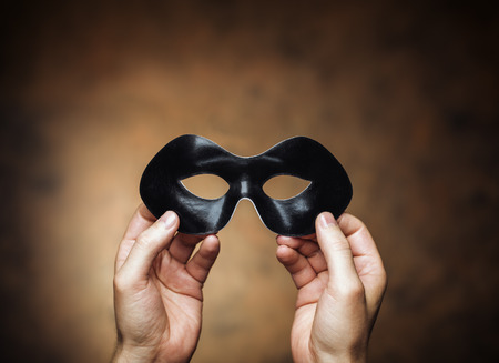 Man holding a black eye mask in his hands.の写真素材