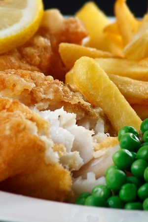 Close up of fish and chips with peas and a slice of lemon  A traditional British Seaside Dishの写真素材