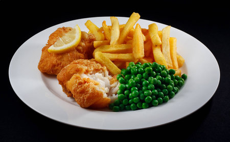 Close up of fish and chips with peas and a slice of lemon  A traditional British Seaside Dishの写真素材