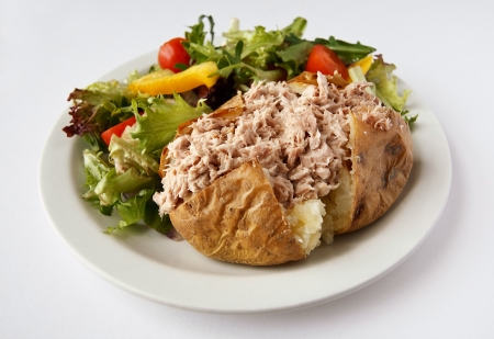 Tuna mayonnaise baked potato on a plate with side saladの写真素材