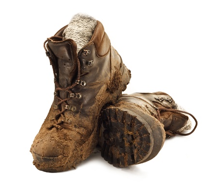 Pair of dirty brown walking boots caked in mud isolated on a white backgoundの写真素材