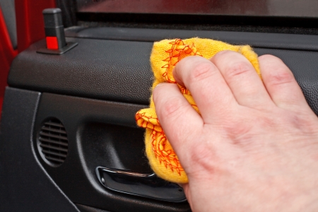 Cleaning the car door interior with yellow polishing clothの写真素材