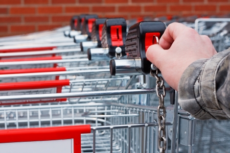 Inserting coin or token into shopping cart at the superstoreの写真素材