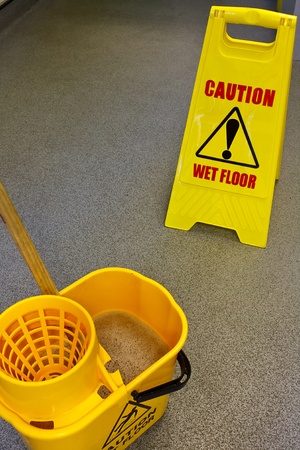 Caution wet floor health and safety sign with mop and bucketの写真素材