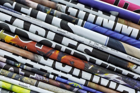 close up on a pile of differnt color newspaper titlesの写真素材
