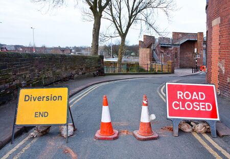 Road closed signs on a small street in the uk to stop cars and keep workmen safeの写真素材