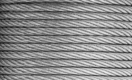 A heavy duty steel rope or cable known as a hawser on a nautical winch great industrial background