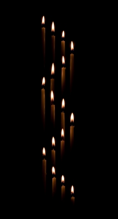 Group of tapered candles form a candle light spiral border with a black backgroundの写真素材