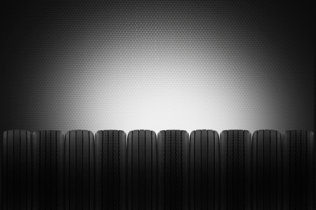 row of radial and cross ply rubber tyres to make background for a tyre sales garageの写真素材