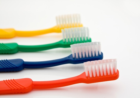 Detail of a row of different colored toothbrushes with the front one in selective focus good for dentistsの写真素材