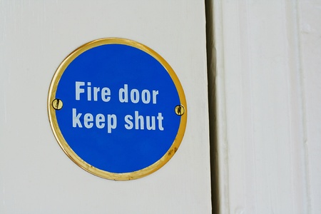 Sign telling people to keep an entrance shut to stop a blaze spreading around a house by being stopped at the fire doorの写真素材