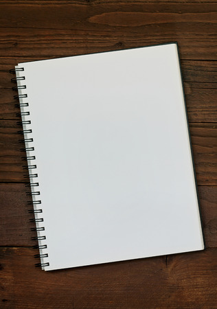 Blank ring bound scrap book on a rustic wooden background with copy space for insertion of your message or design elements.の写真素材