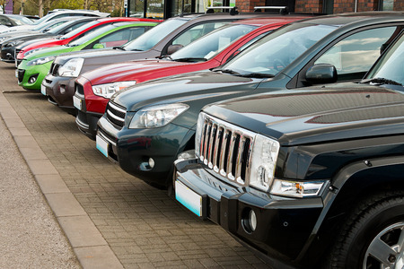 Row of used four by four motorcars also known as 4x4, SUV, off road, utility vehicle, ute or Station wagon arranged for sale on a motor dealers forecourt these types are becoming popular choices to buy as a new family car with off road capability but justのeditorial素材