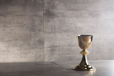 Gold chalice on stone table and backgroundの写真素材