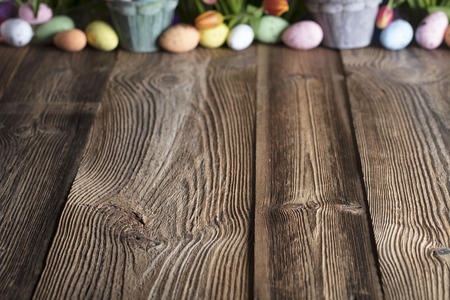 Easter eggs. Colorful bokeh, place for typography . Rustic wooden table. Easter theme.